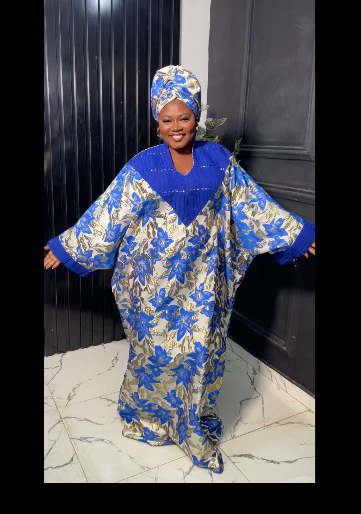Woman wearing a blue and gold traditional outfit with a matching headscarf 